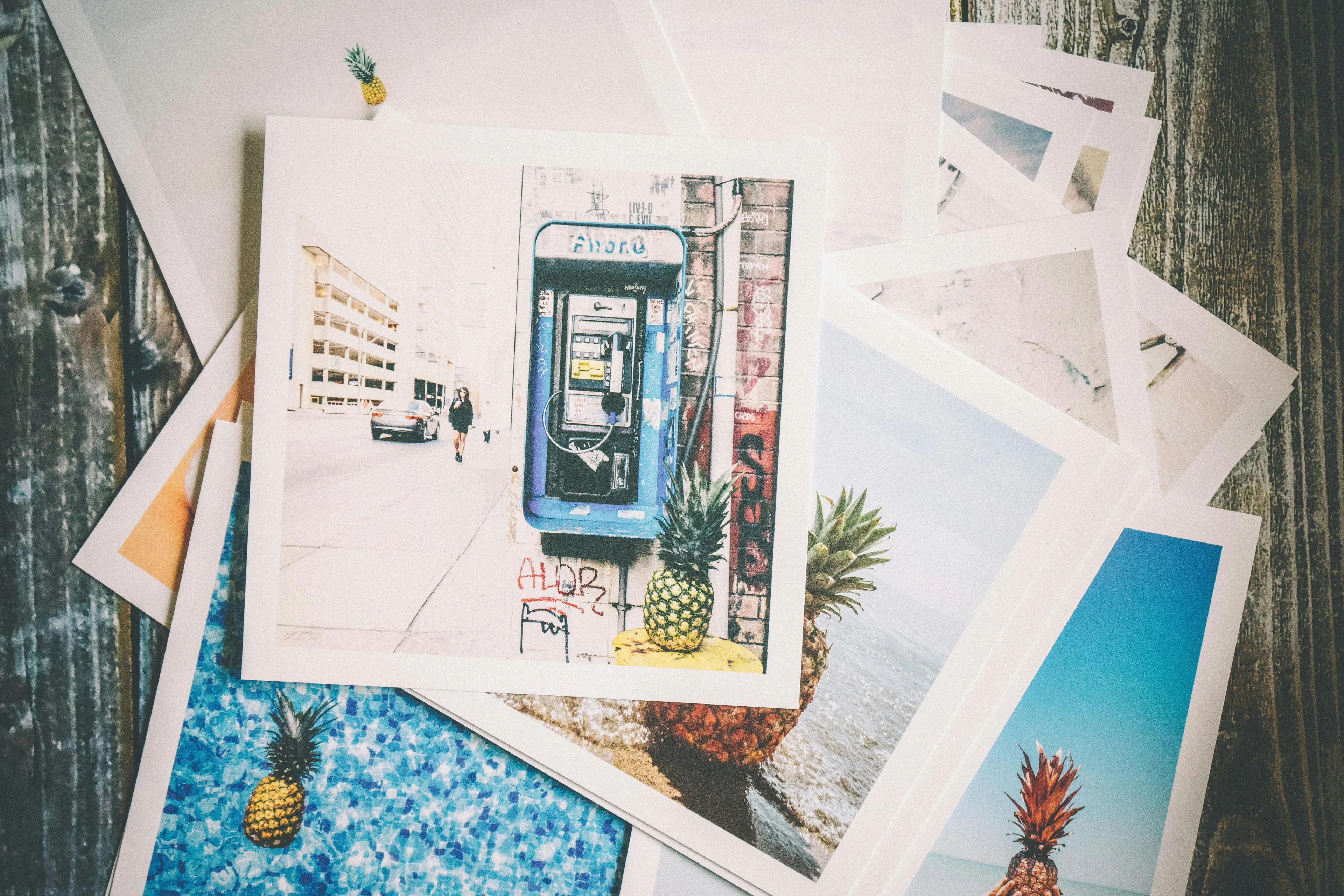 Stack of vacation photos featuring pineapples and various scenes, illustrating decision making style decoder choices.