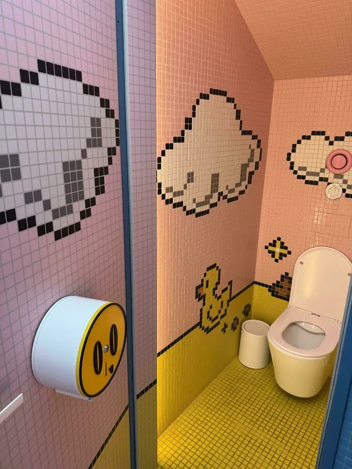 Bathroom with pixel art tiles depicting clouds and ducks in minimalism design