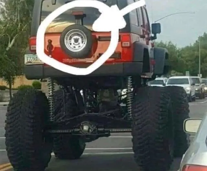 Humorous post showing a large lifted vehicle with a tiny spare tire circled, highlighting uncultured and ignorant Americans.