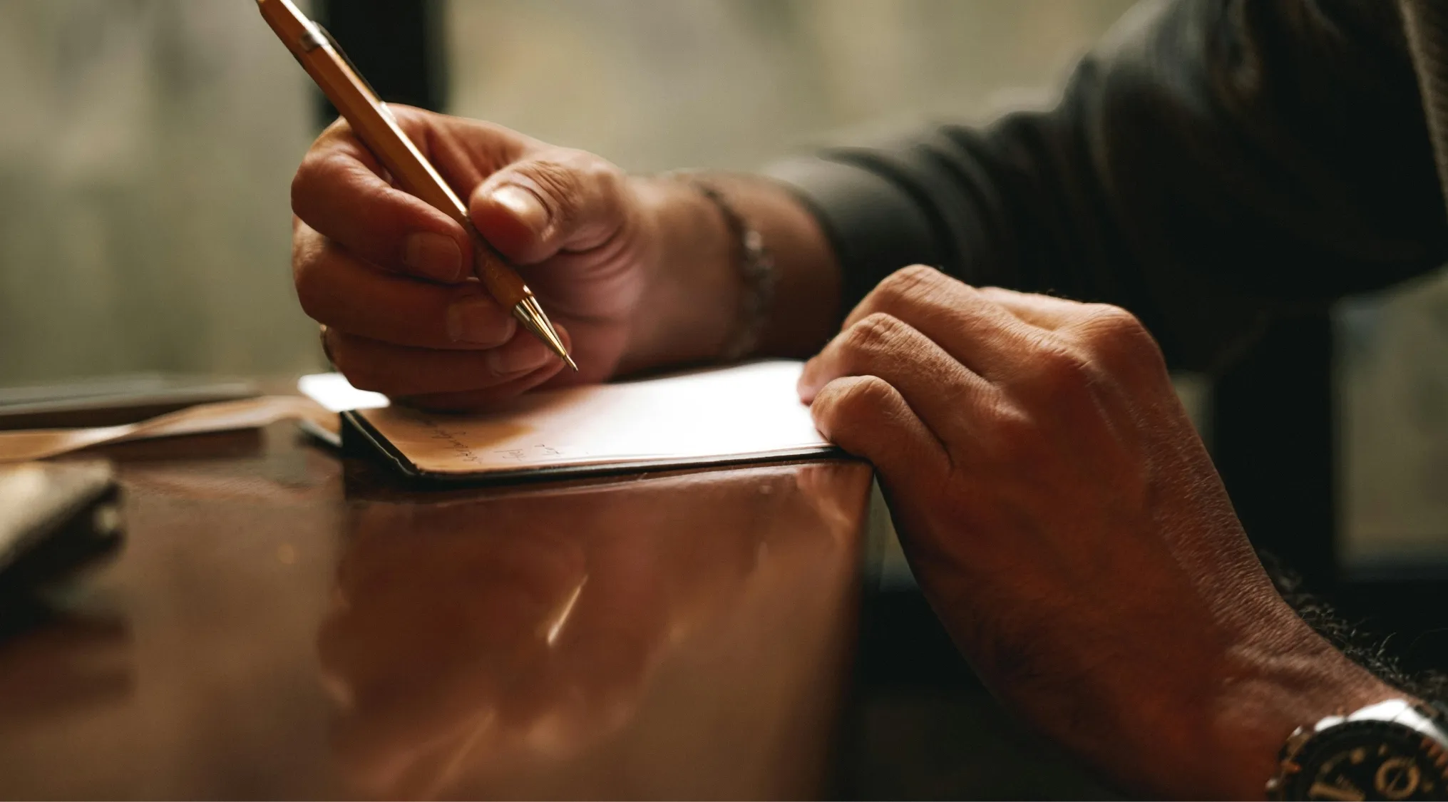 Close-up of a person writing with a pen on paper, focusing on literary skills in a language quiz setting.