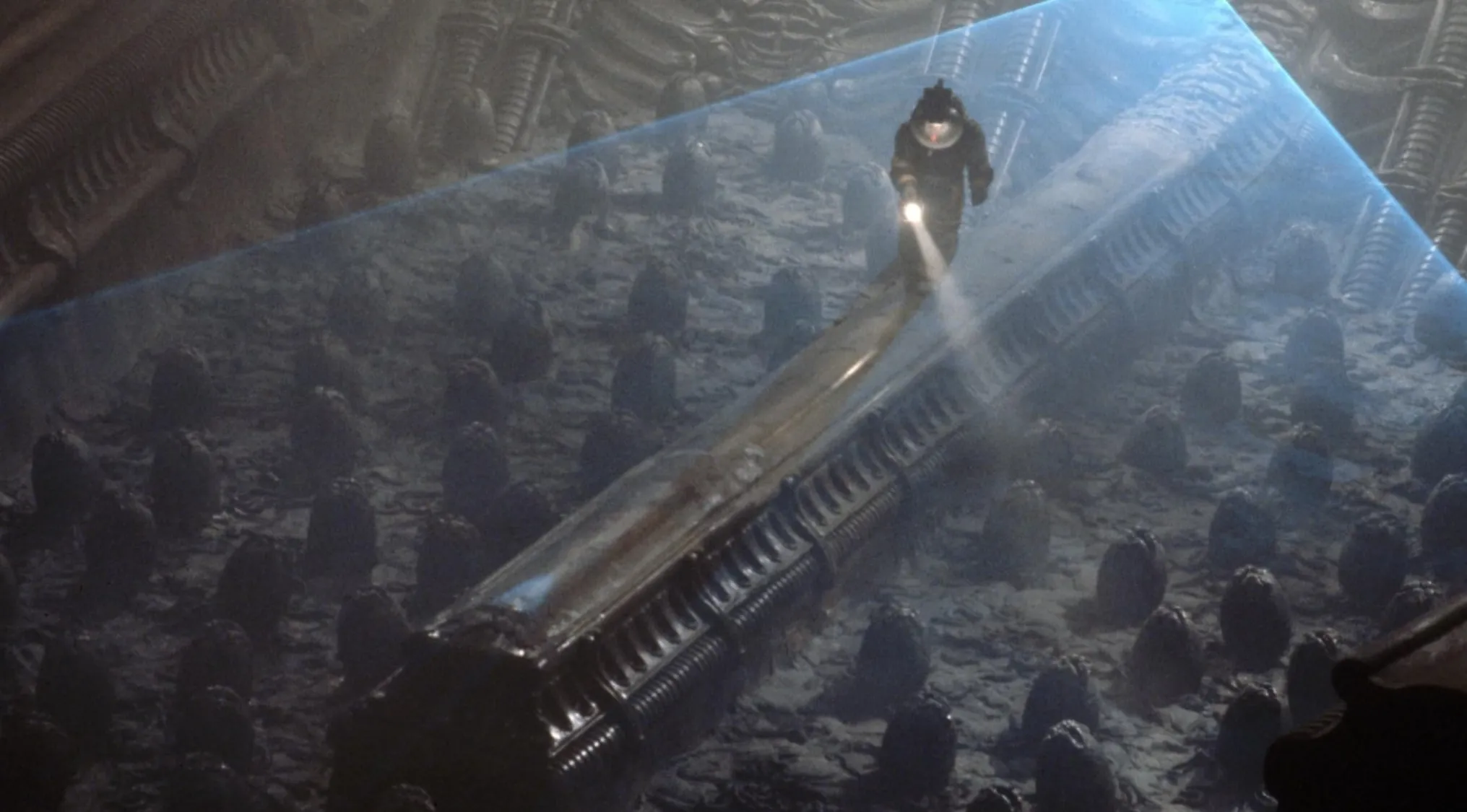 Astronaut exploring an alien chamber with eggs inside a dark sci-fi 70s movie scene.