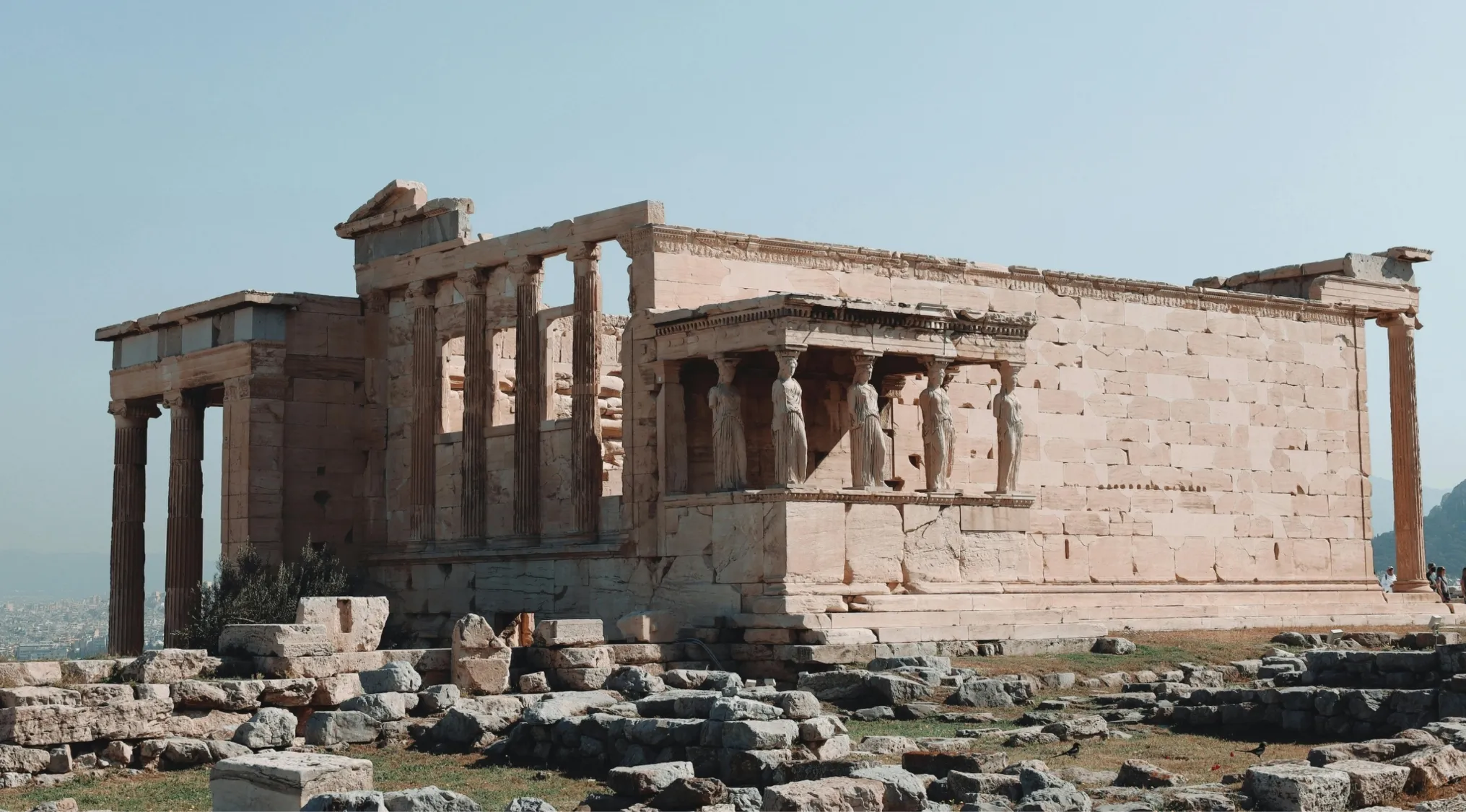 Ancient stone temple with columns and statues, a geography challenge to guess the country of this landmark.