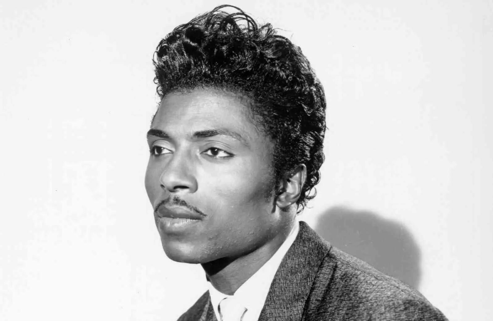 Black and white portrait of Little Richard, influential rock and roll singer from the 1950s with styled hair and suit jacket.
