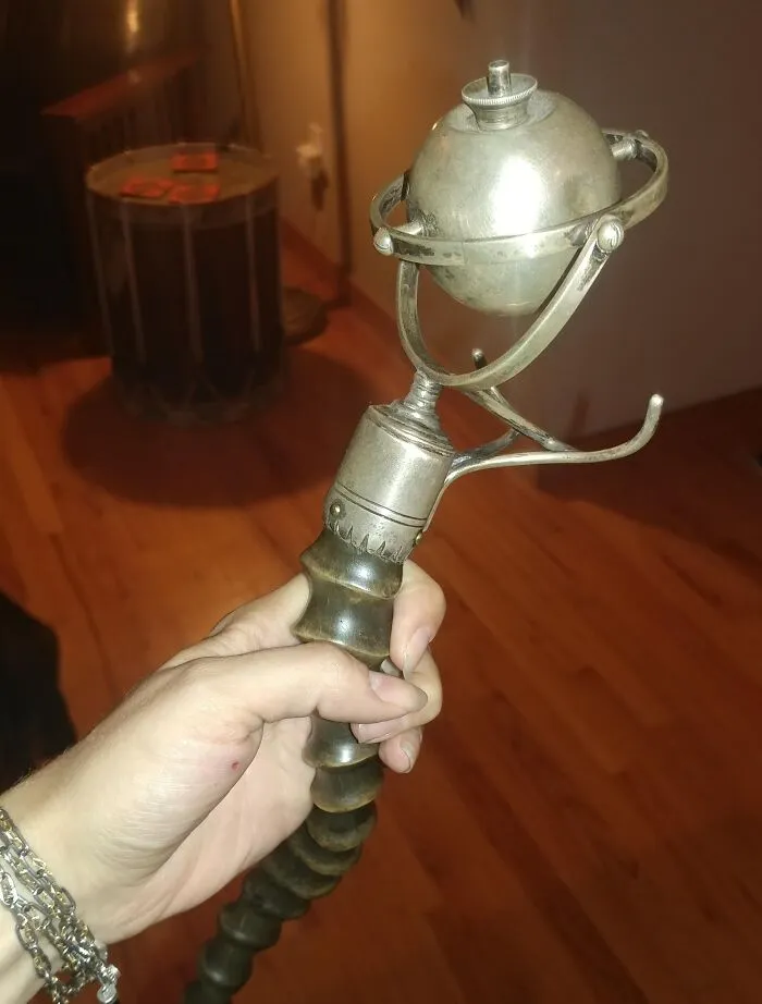 Hand holding a vintage metal object with a spherical top, featured in internet mystery of unidentified objects solved.