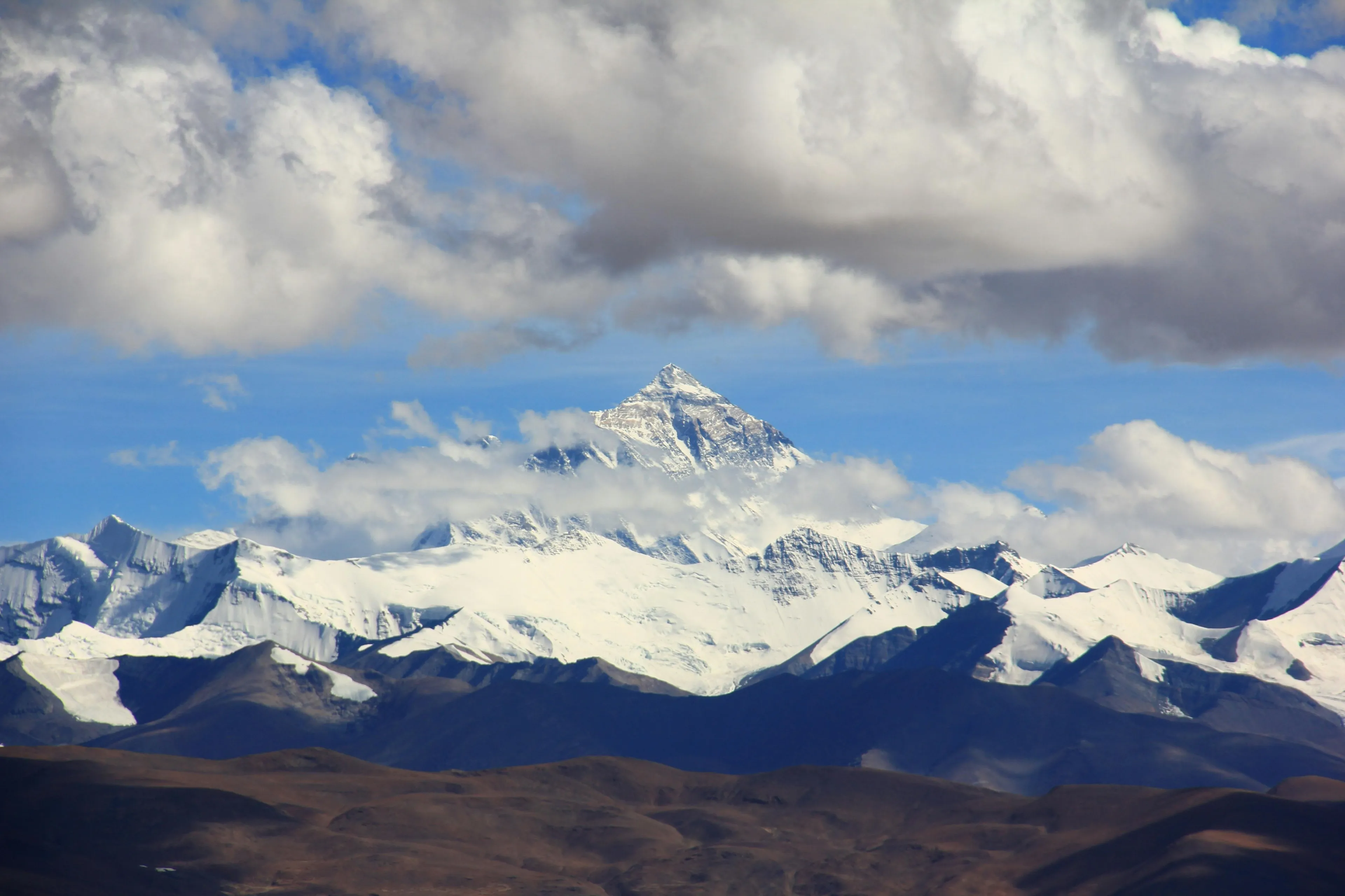 Snow-covered Mount Everest towering in the Himalayas mountain range beneath a cloudy sky in a quiz challenge setting.