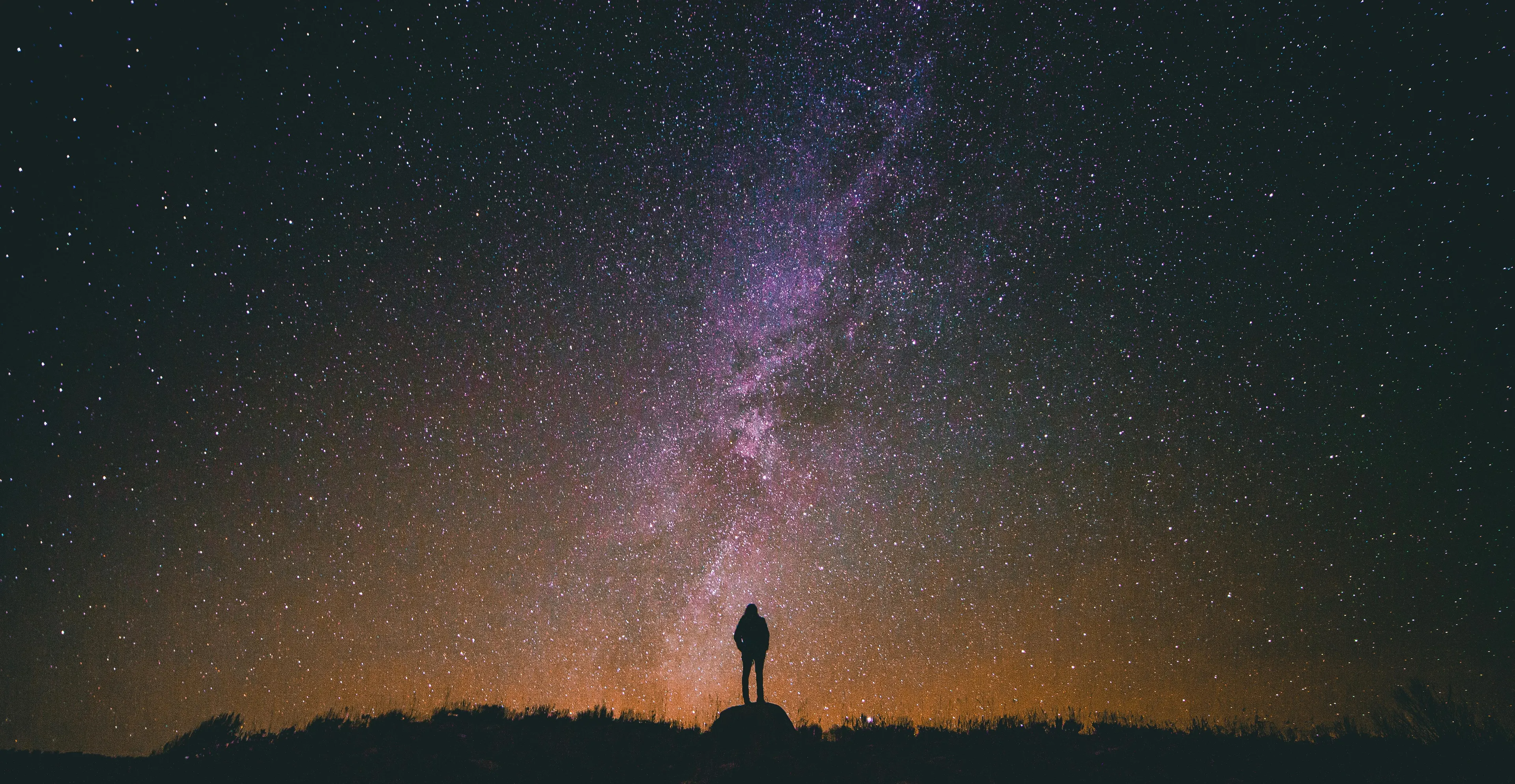 Silhouette of a person stargazing under a vast night sky filled with stars, illustrating the study of stars concept.