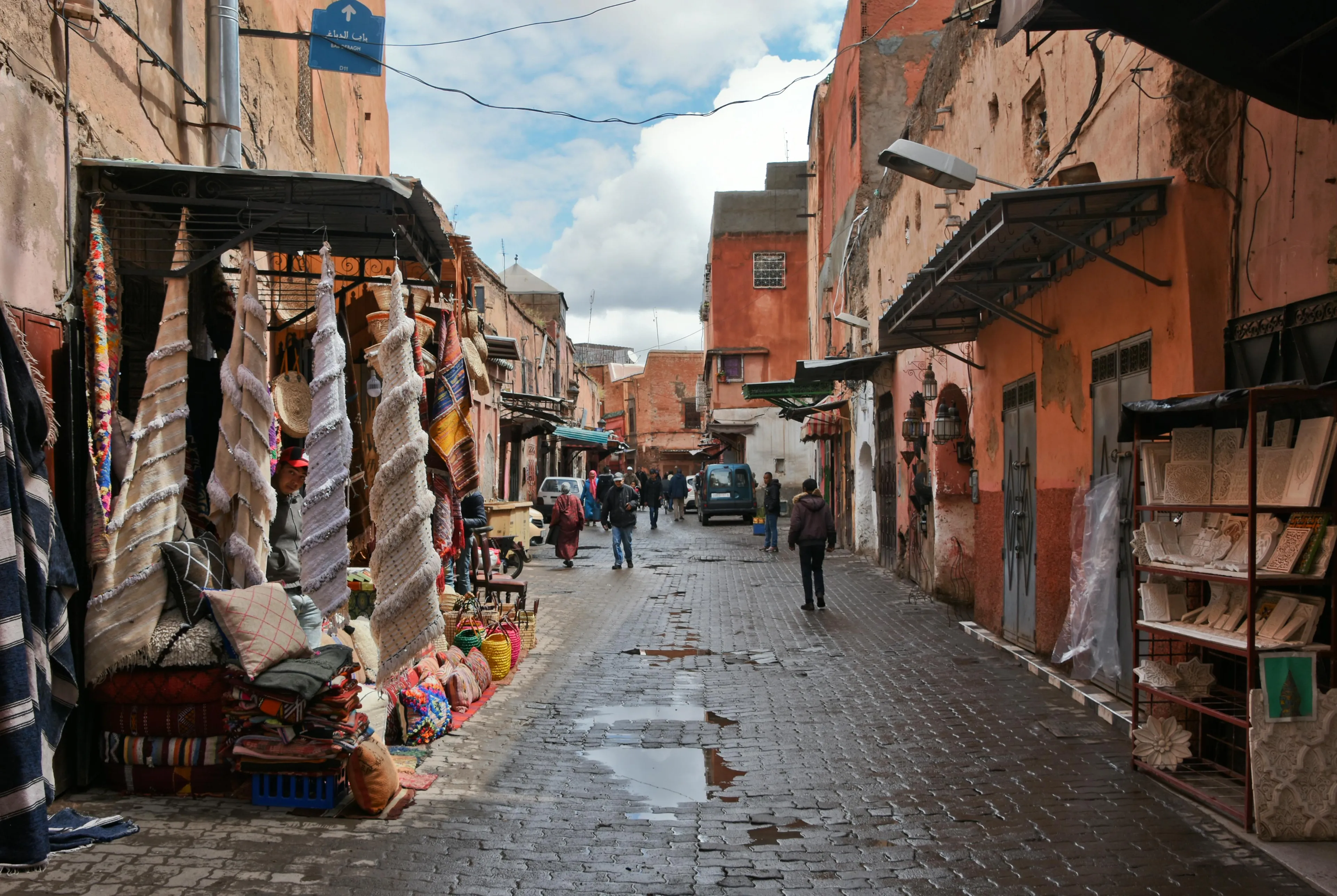 Street market with textiles and crafts in Marrakech, Morocco, showcasing local culture and traditional shopping experiences.