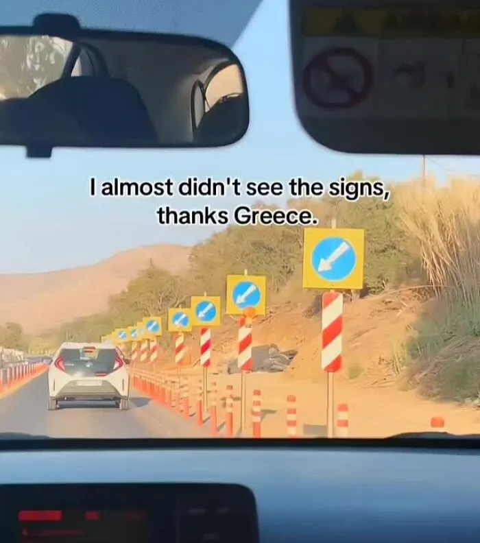 Multiple road signs with arrows pointing right along a rural road, a meme showing excessive signage humor related to memes.