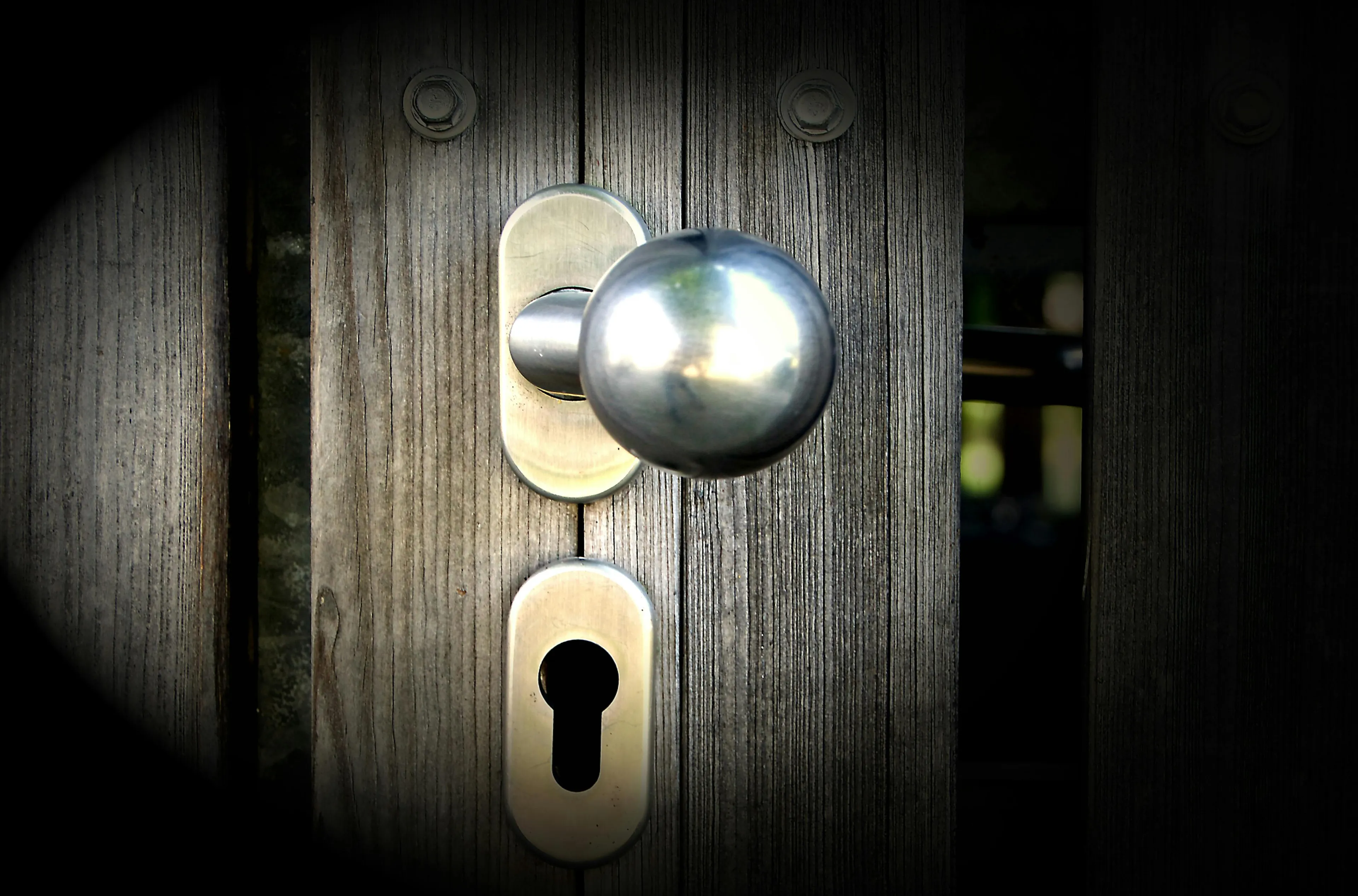 Close-up of a metal doorknob on a wooden door illustrating general science knowledge about temperature perception.