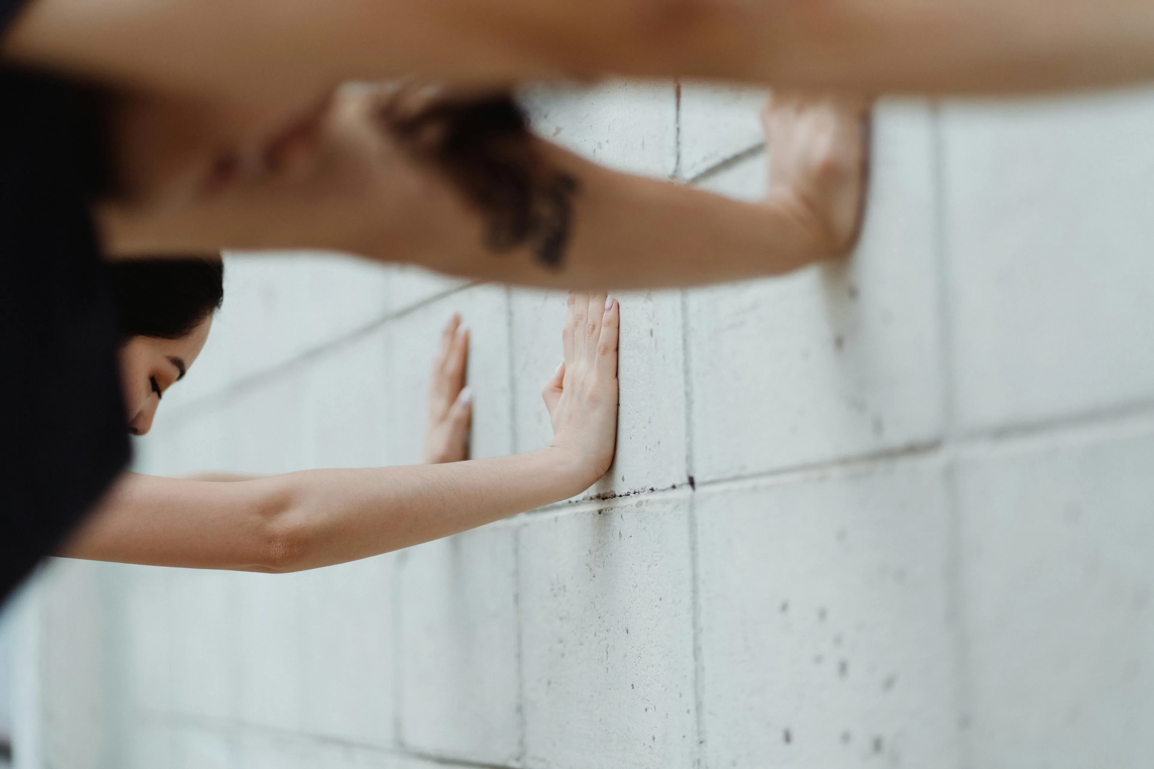 Person pushing off a wall with hands illustrating the law of action and reaction explaining their motion on a skateboard.