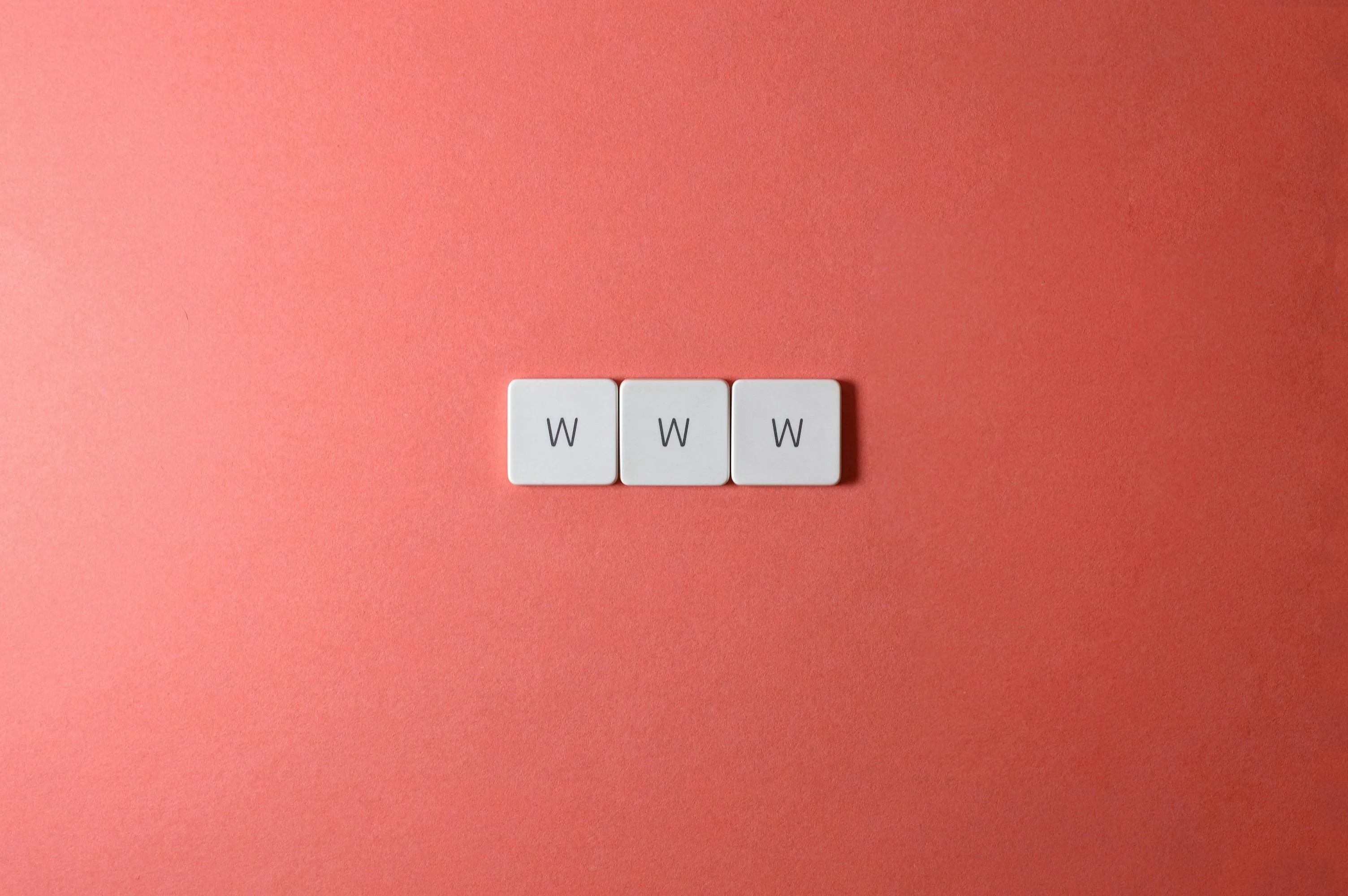 Three white keyboard keys with the letters W W W on a red background representing website URL quiz concept.