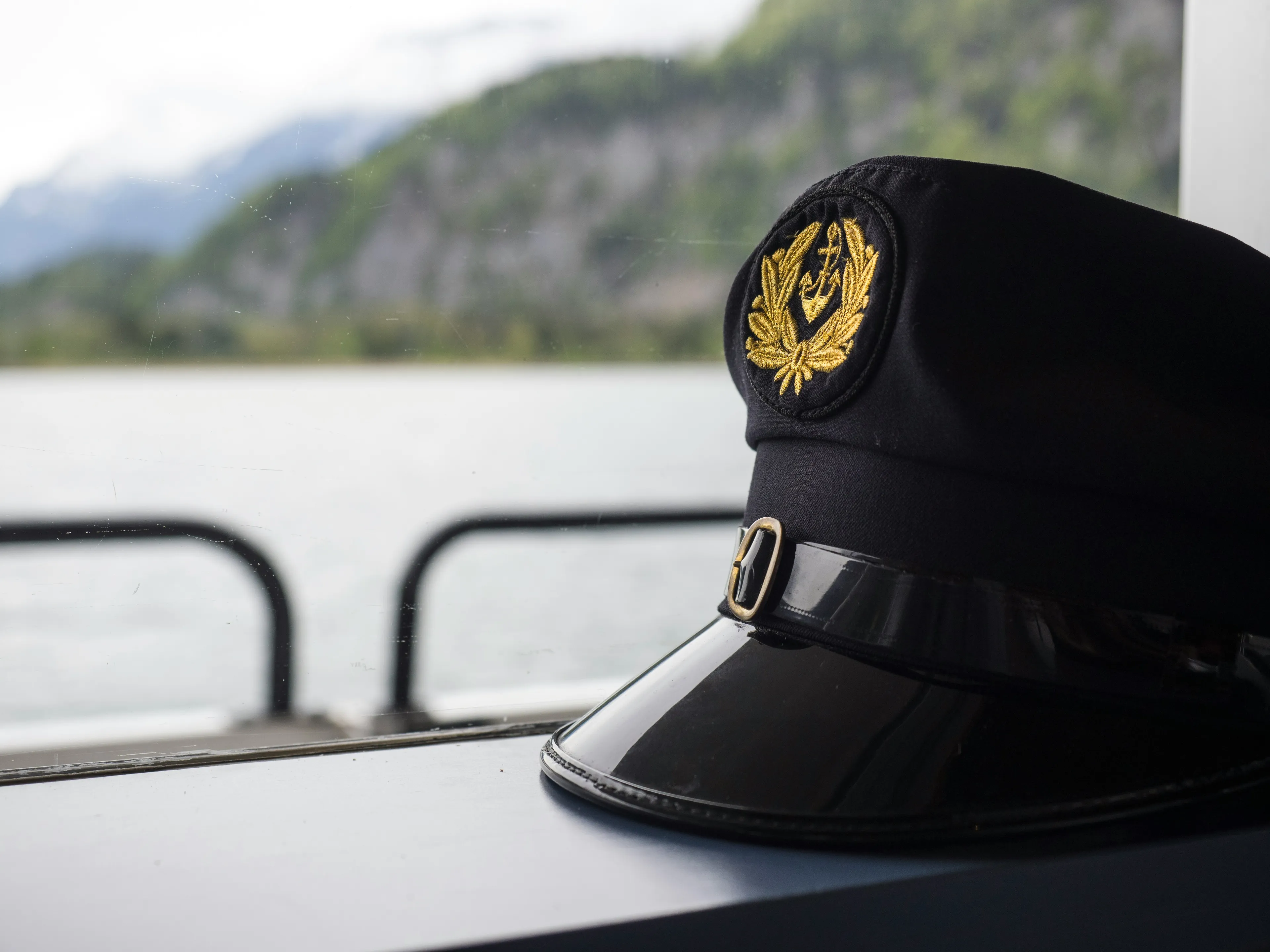 Captain's black peaked hat with gold insignia on a ship window ledge, related to general knowledge quiz.