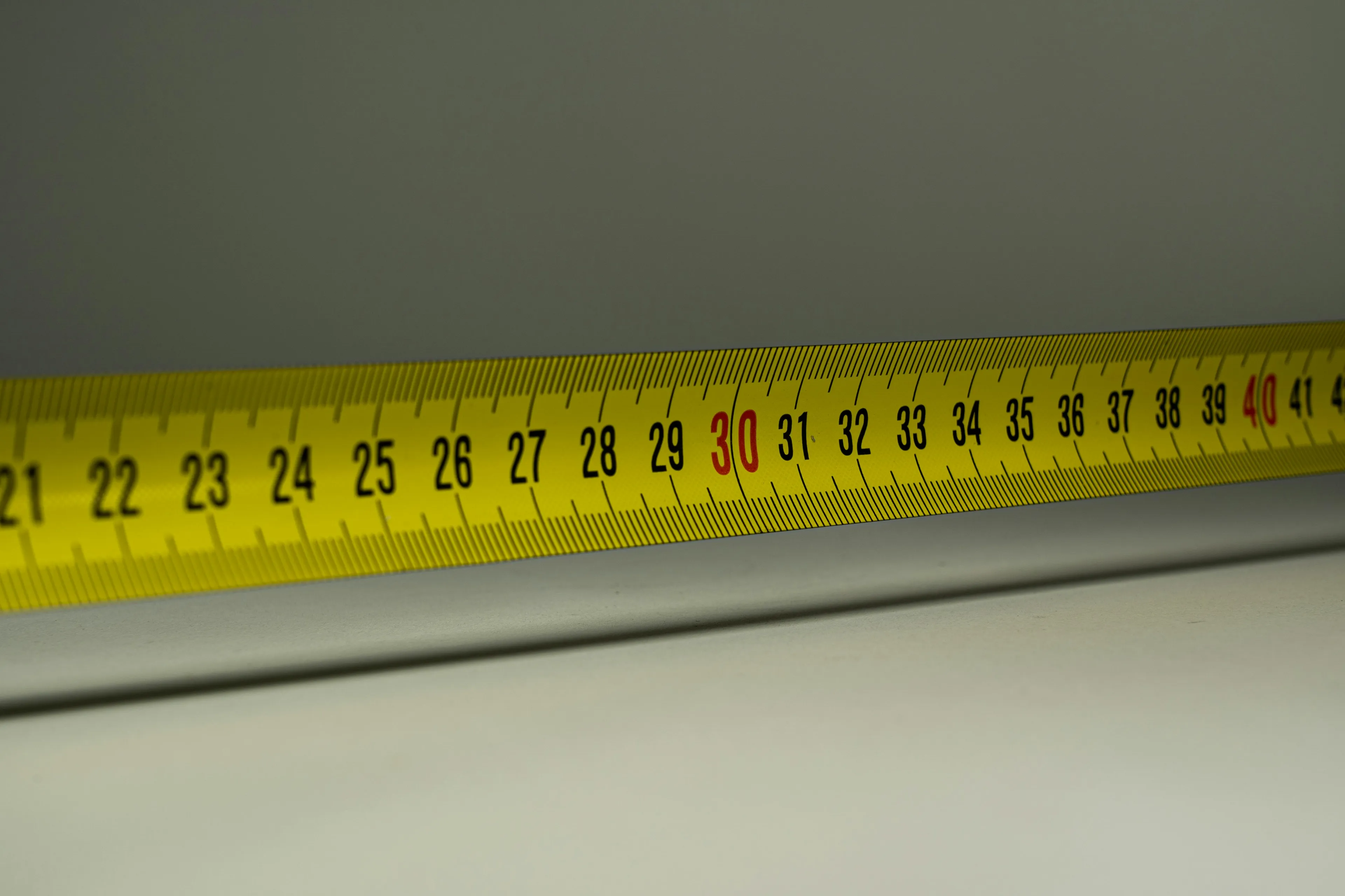 Yellow measuring tape showing centimeters for an easy-to-hard general knowledge quiz question on length conversion.