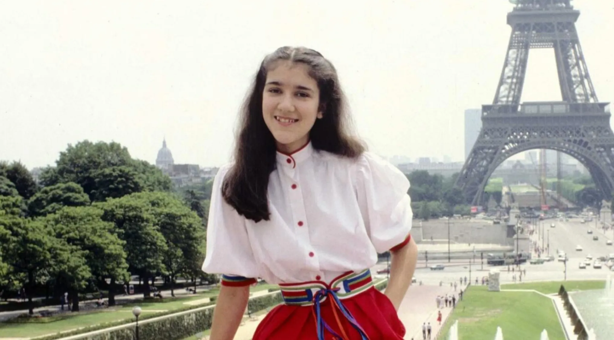 Young girl posing near the Eiffel Tower in Paris, part of a celebrities as kids photo collection.