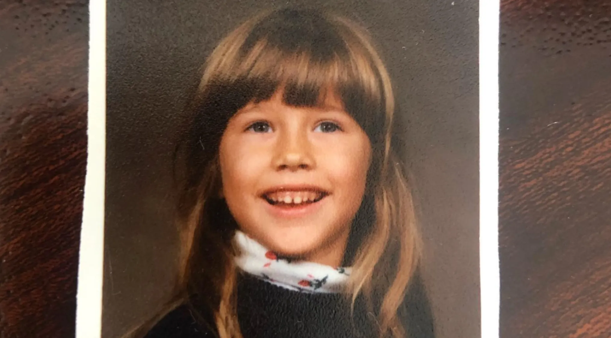 Childhood photo of a smiling girl with long hair, part of a celebrities as kids guess the celeb challenge.