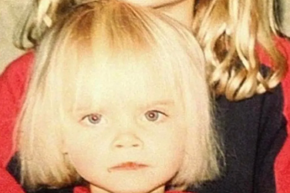 Child with blonde hair and light eyes, questioning which one is Adele in a vintage-style photo.