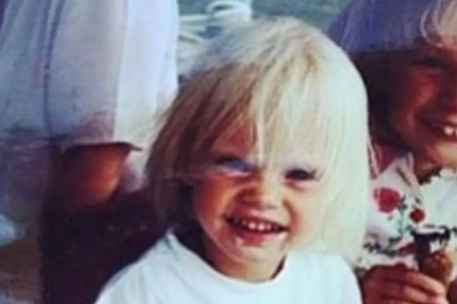 Blond toddler smiling with siblings in a casual setting, a playful moment capturing a young Brie Larson.