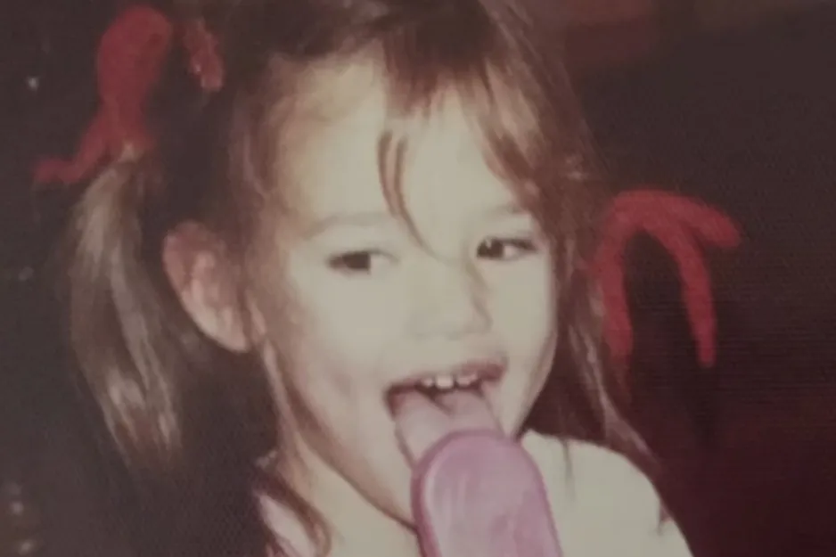Young girl with pigtails enjoying a pink popsicle in a candid childhood photo spotting Brie Larson.