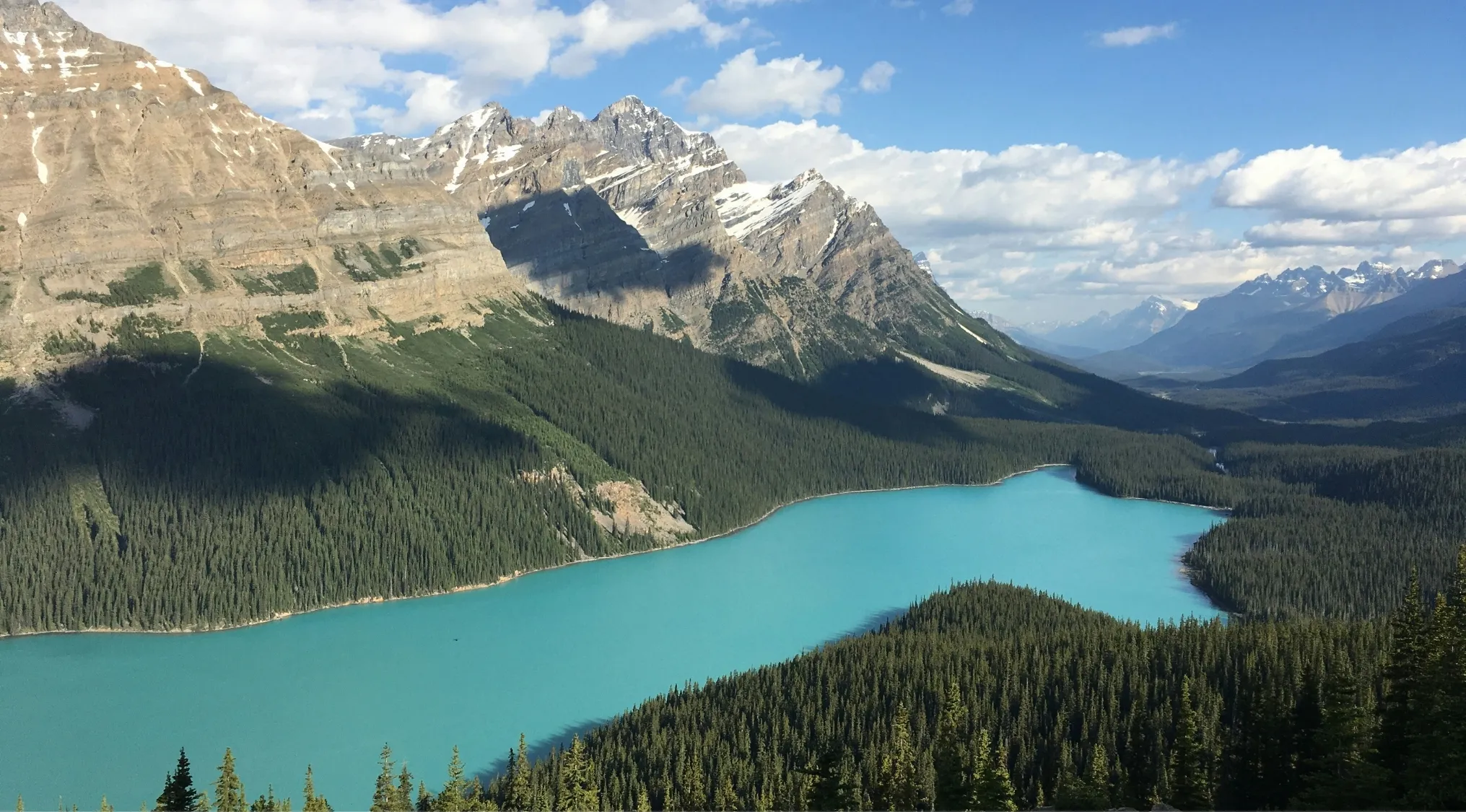 Turquoise natural lake surrounded by dense forest and mountains, illustrating the country with the most natural lakes.