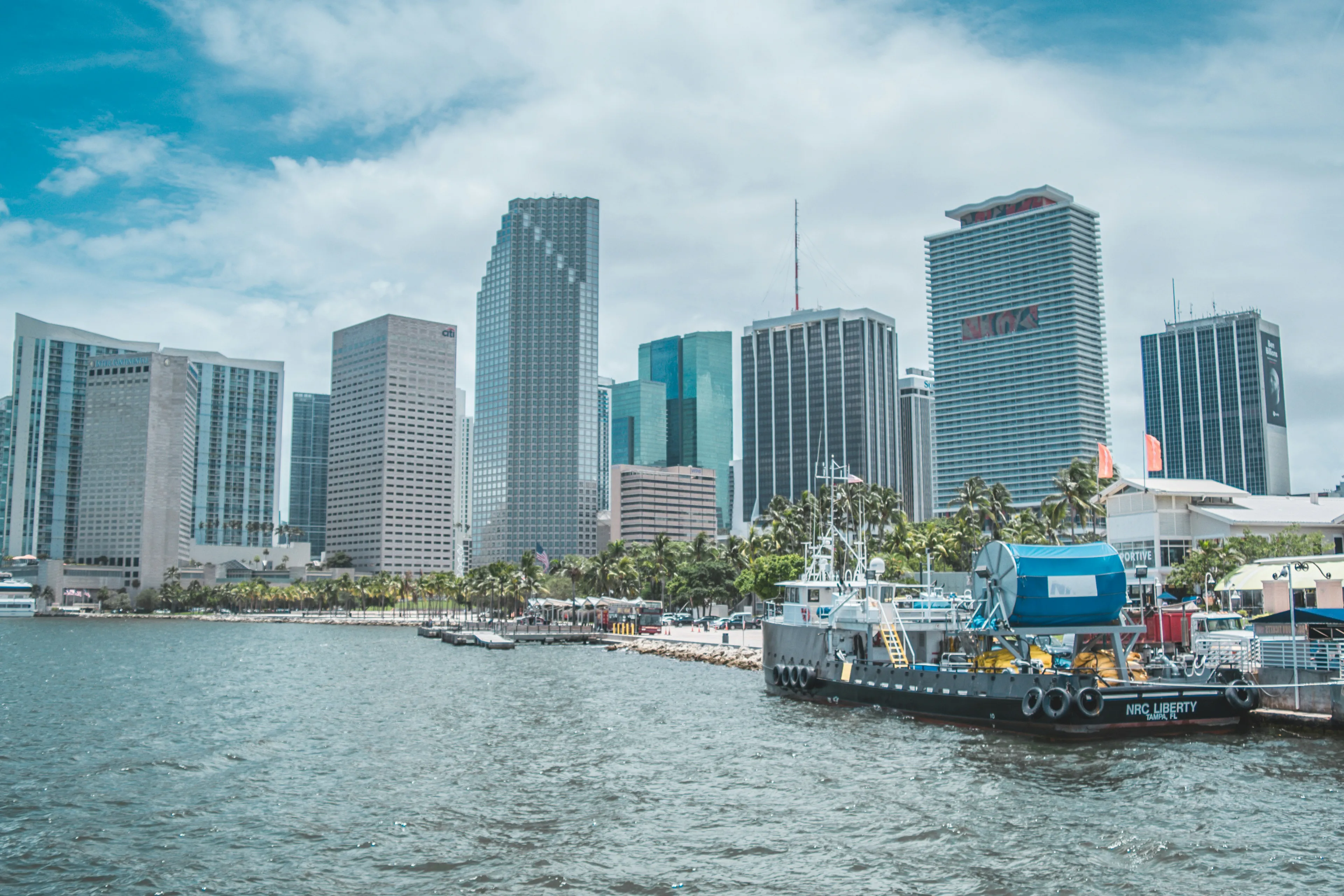 Miami city skyline with waterfront and boats under a bright blue sky, highlighting Miami USA southern location.