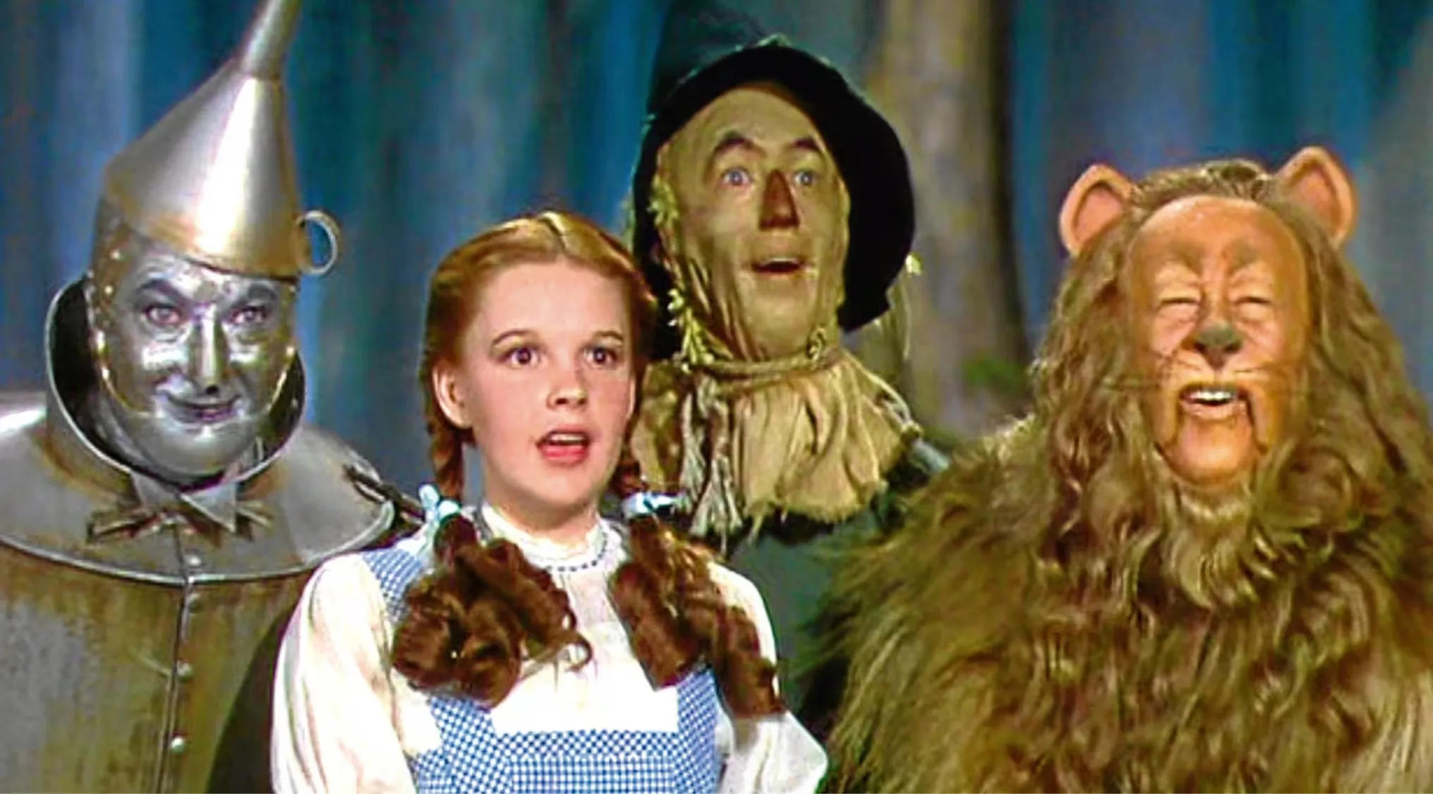 Scene from The Wizard of Oz showing Dorothy and her companions, focusing on Dorothy's iconic slippers color question.