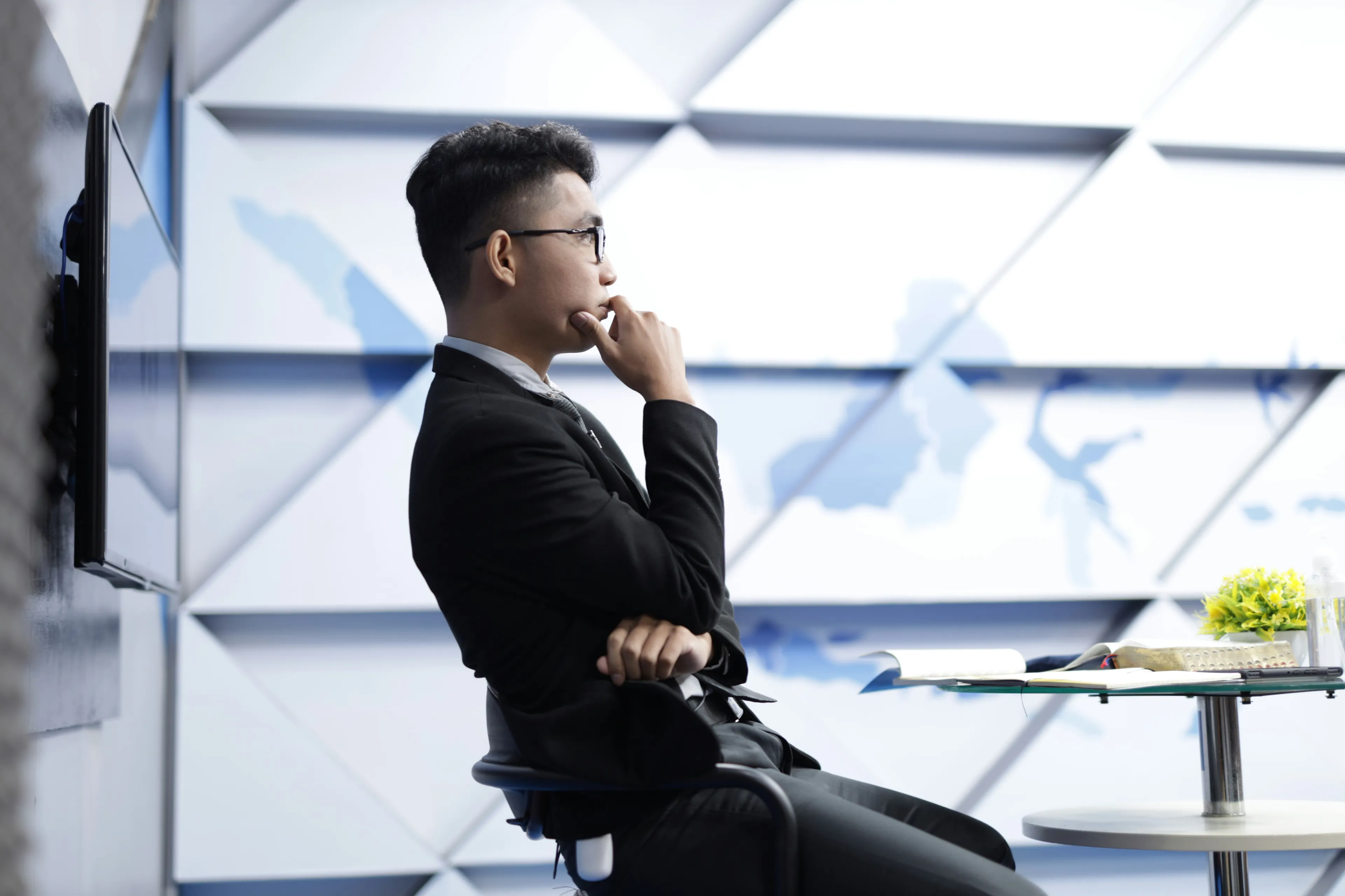 Man in a suit thinking thoughtfully with a world map in the background, symbolizing general knowledge quiz on African countries.