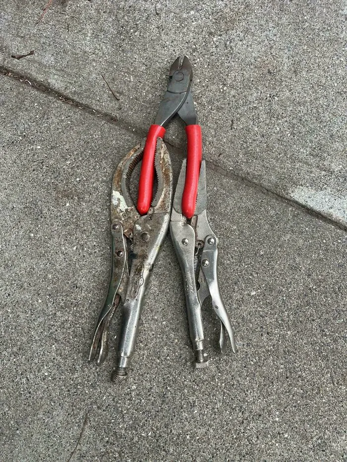A pair of pliers holding vice grips upright in a clever solution for random junk.