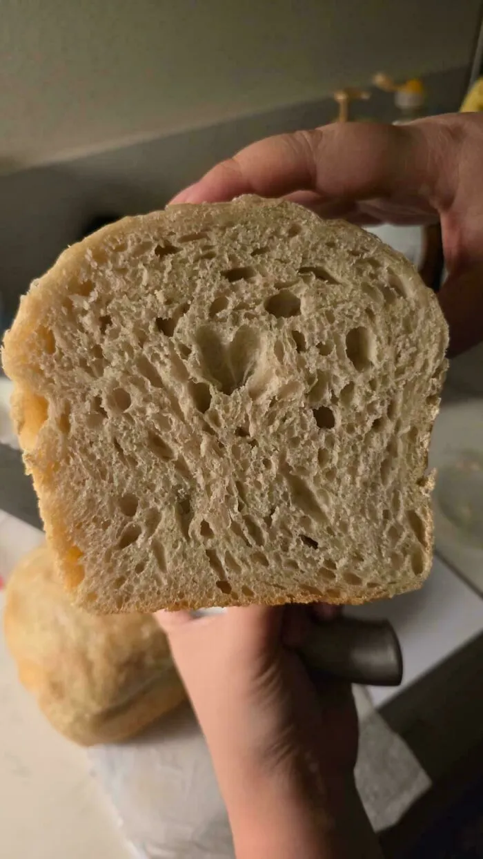 Freshly baked bread slice showing soft texture and holes inside
