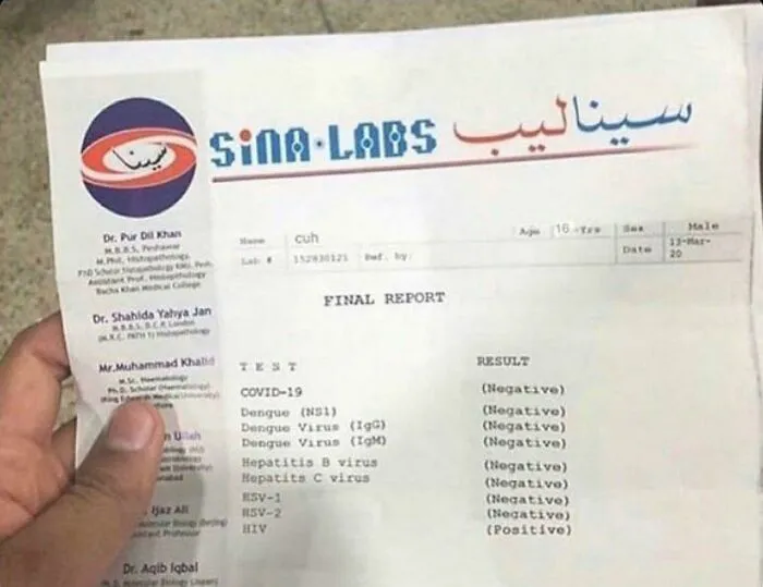 Hand holding a medical lab report showing multiple negative virus test results with one positive HIV result.