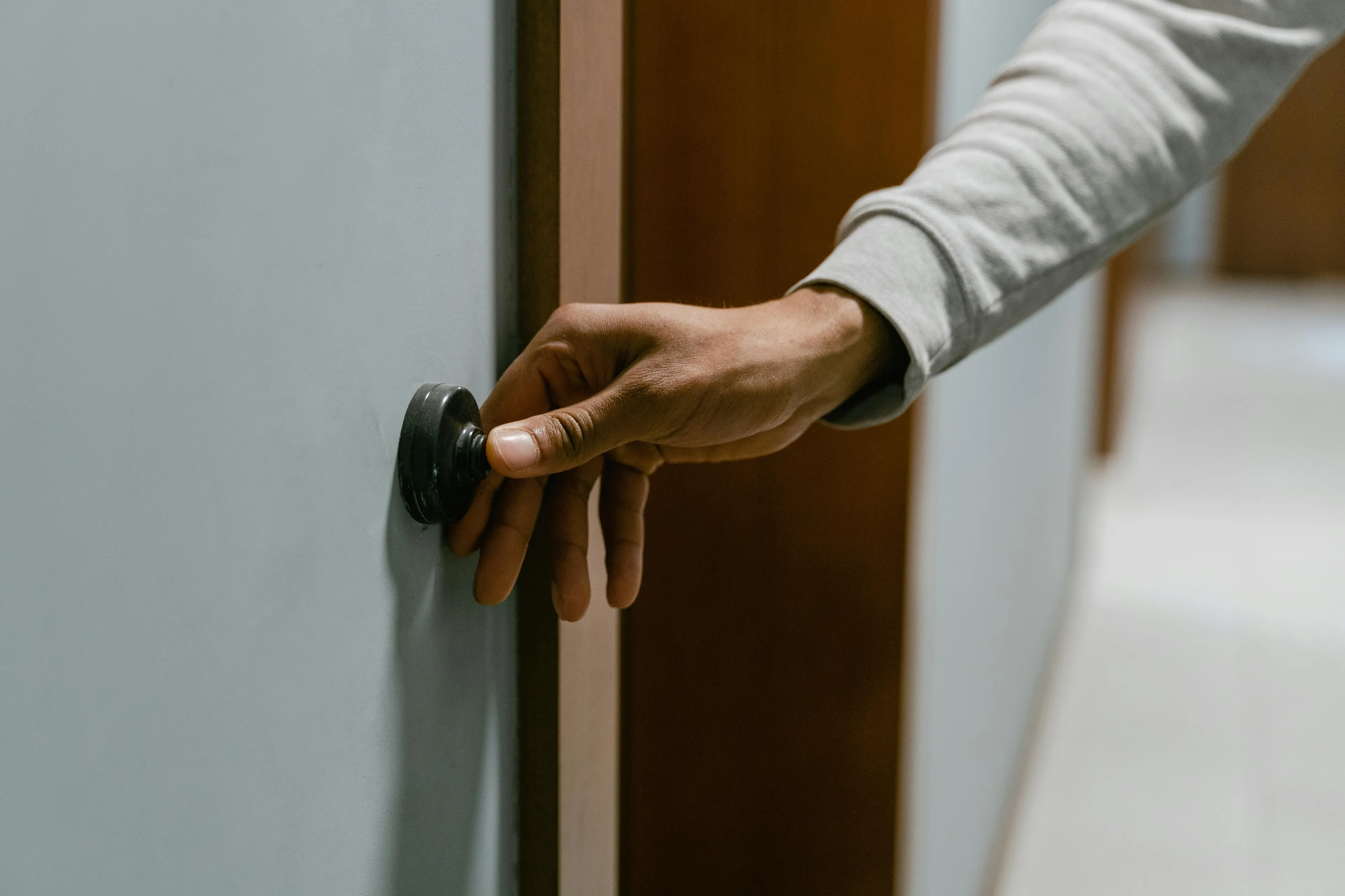 A person pressing a doorbell button, illustrating the concept to unlock your inner group role in social interactions.