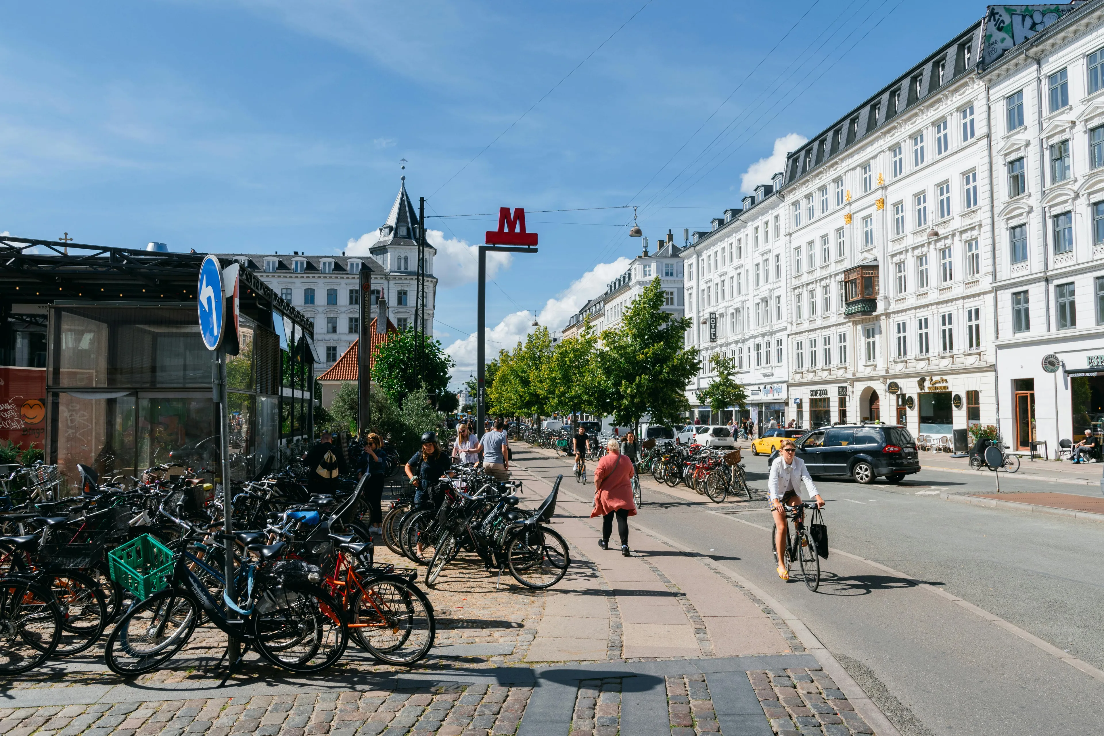 Bicycles parked along a street with people cycling and walking in a European city known for its cycling culture.