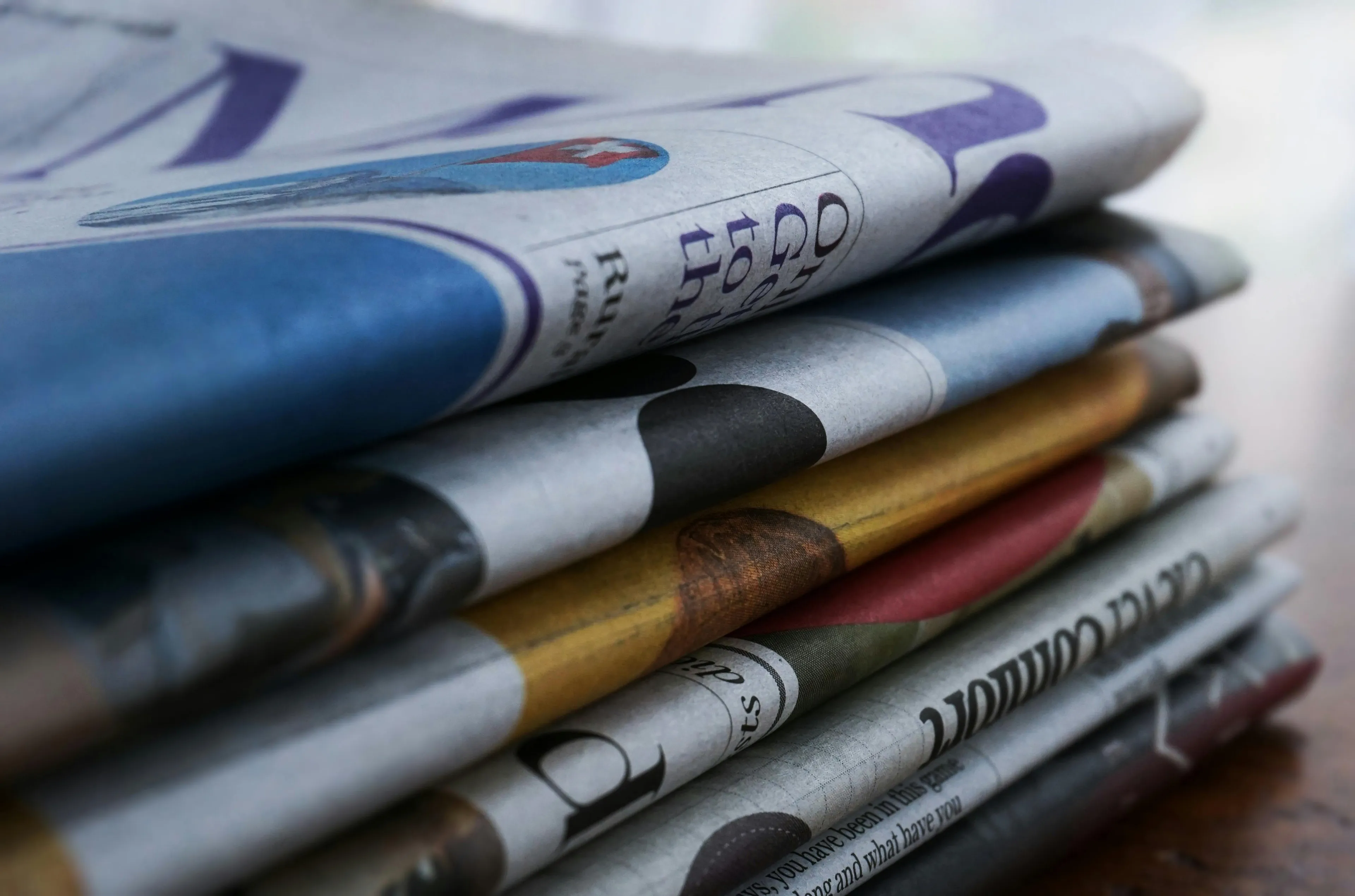 Stack of folded newspapers representing countries that were first to adopt freedom of the press law and minimalist design.