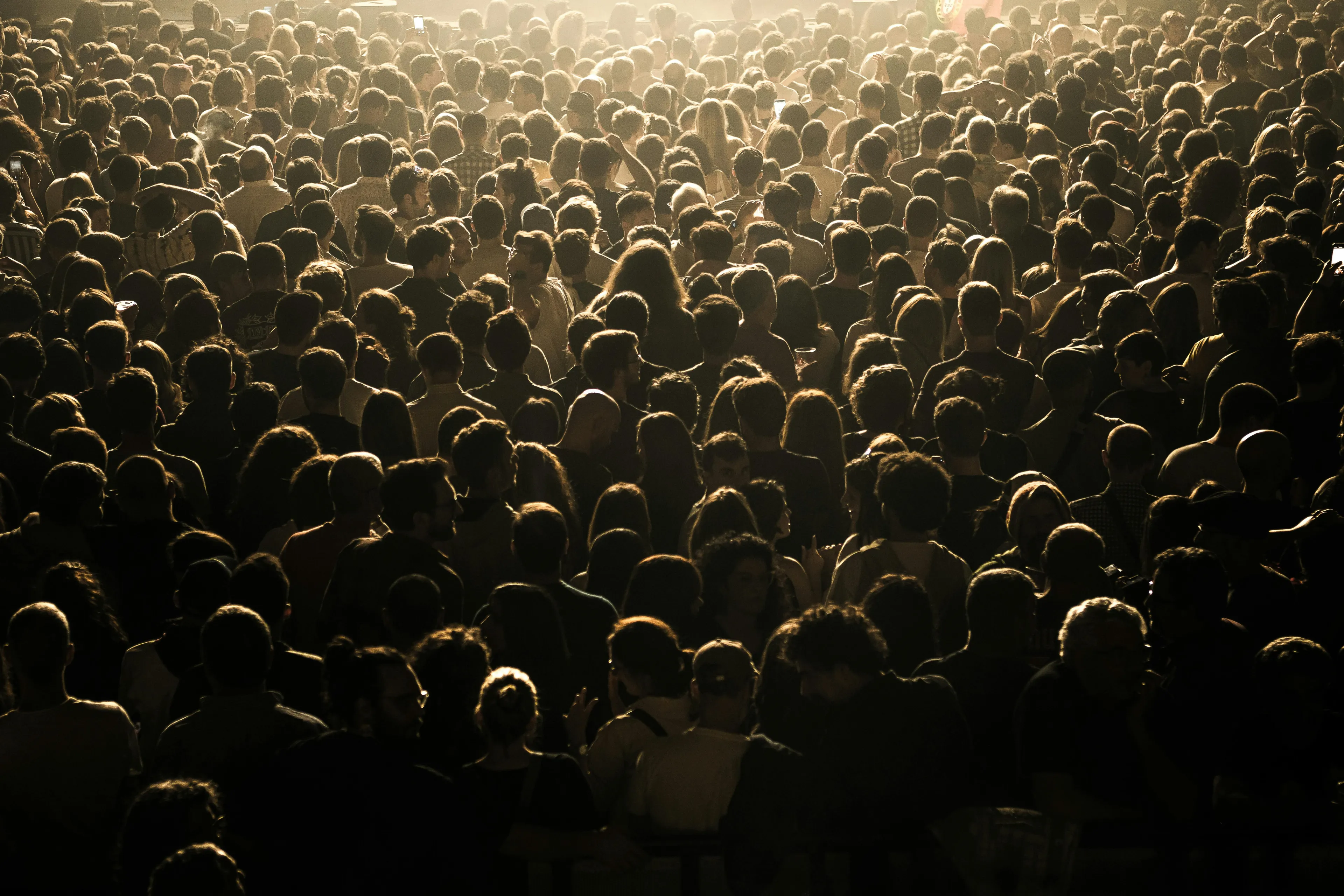Large crowd of people densely packed together representing population growth in countries that were first to reach milestones.