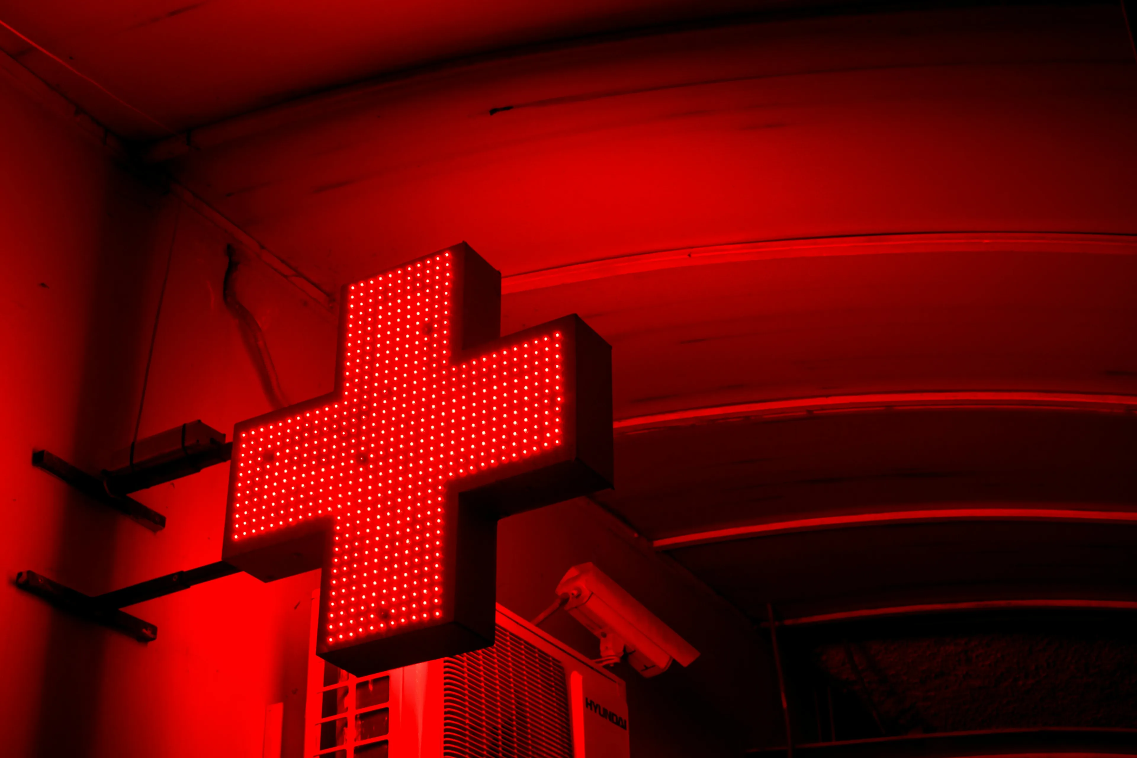 Red illuminated cross sign symbolizing humanitarian aid and countries that were first in international wartime relief efforts.