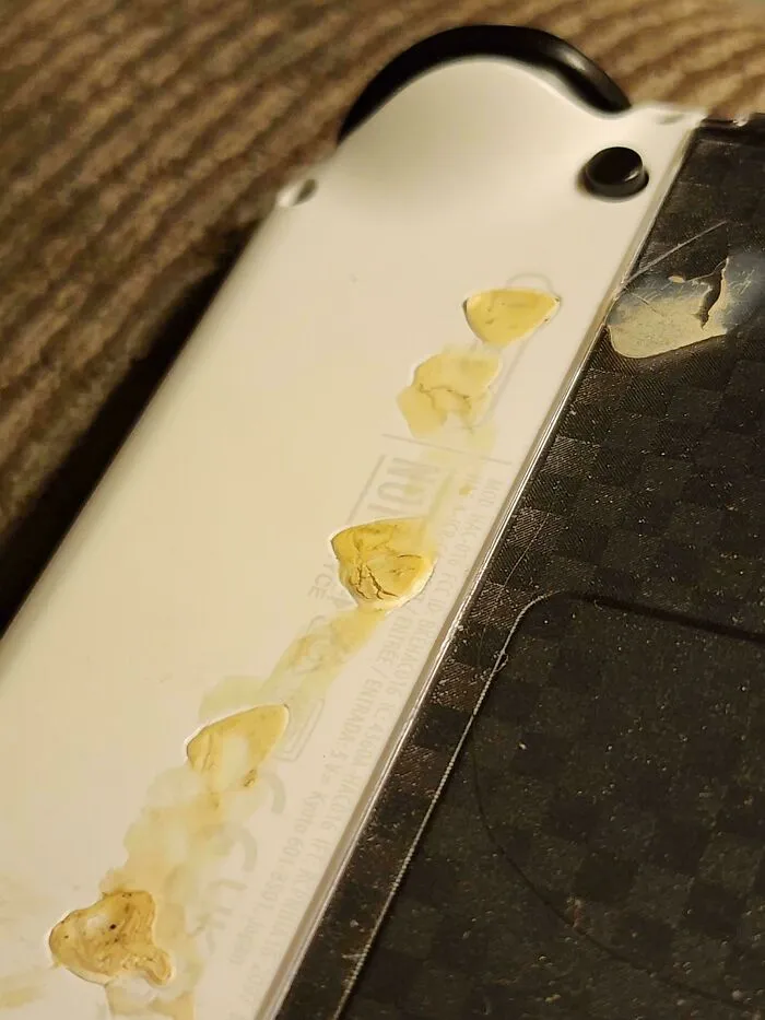 Let My 17-Year-Old Brother Borrow My Switch For His Trip, And He Brought It Back With Something Fused To The Plastic. He Has No Idea What It Is