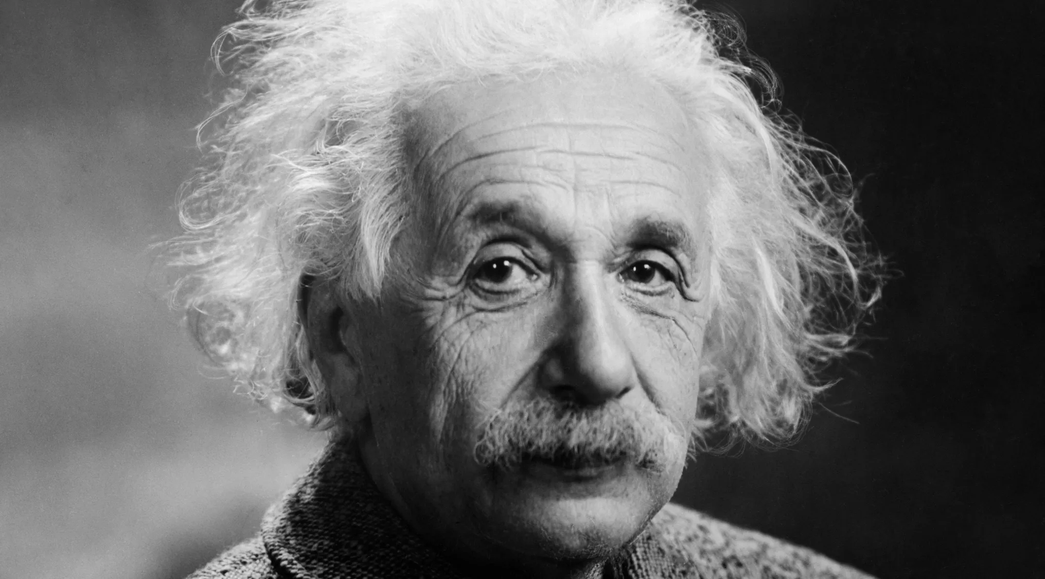 Black and white portrait of an elderly man with wild white hair, illustrating the idea of two truths and a lie factoid game.
