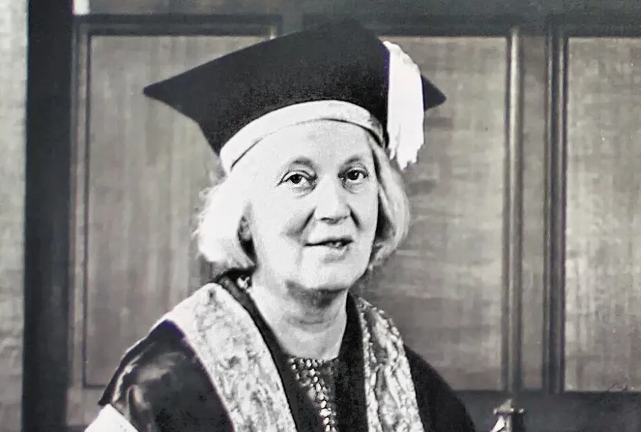 Black and white portrait of Dorothy Hodgkin, the first woman Nobel Prize winner, wearing academic regalia and a graduation cap.