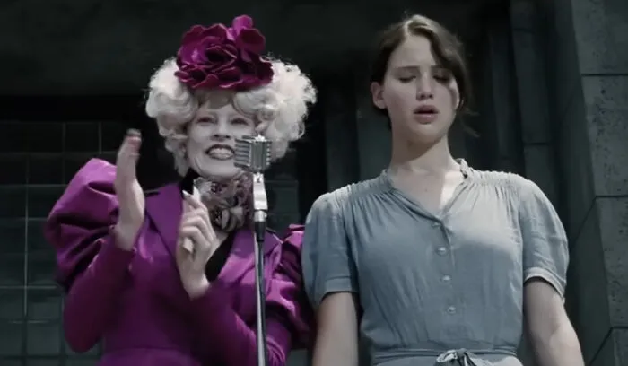 In The Hunger Games, Katniss makes the tough decision to volunteer as a tribute after she finds out that her younger sister was chosen for the games. Not only does this action save her sister, but it also makes her a symbol of hope in the dystopian world.