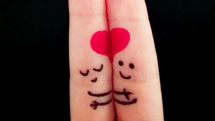 Two fingers painted with faces and arms hugging, forming a heart, illustrating things everyone thought were unique as a kid