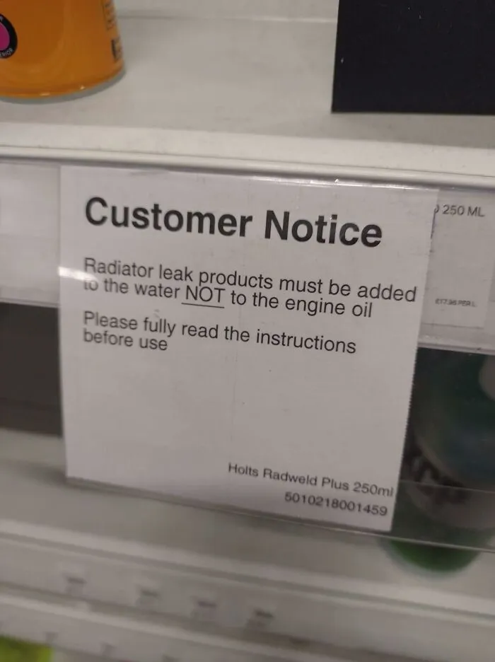 Customer notice sign warning that radiator leak products must be added to water, not engine oil, highlighting uncultured Americans.