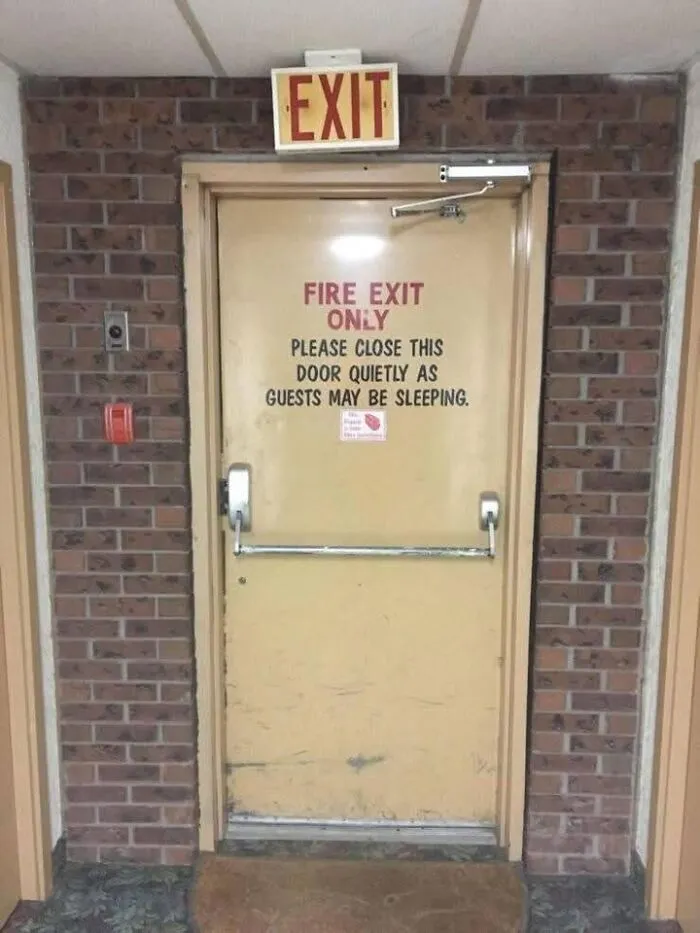 Fire exit door with sign asking to close quietly as guests may be sleeping, highlighting uncultured and ignorant Americans.