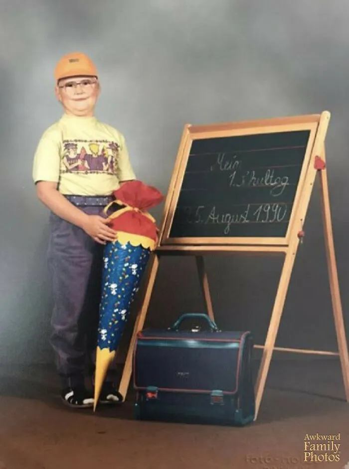 My Husband’s 1st Day Of School Dressed In A Cap That Looks Like A Helmet, Old School Glasses And White Socks & Sandals While Holding His School-Issued ‘Schultuete’ Which Every Kid In Germany Gets On The First Day Of School. And Yes, That Is His Blue Briefcase