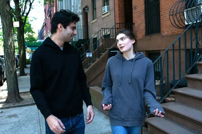 A woman calmly shutting down a man’s creepy advances during a conversation on a city sidewalk.