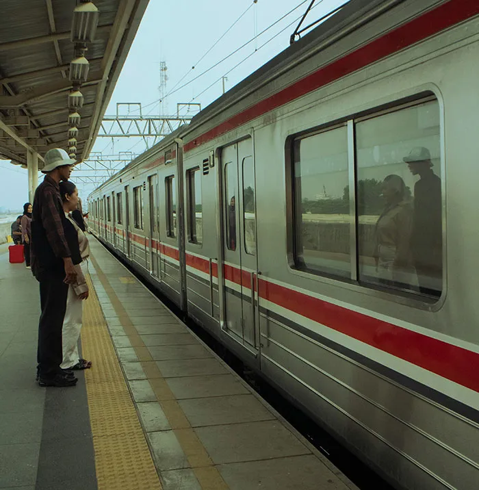 Two people standing on a train platform experiencing eerie and unexplained reflections in the train windows.