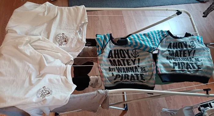 Clothes drying on rack, featuring pirate-themed shirts, capturing eerie and odd vibes related to unexplained experiences.