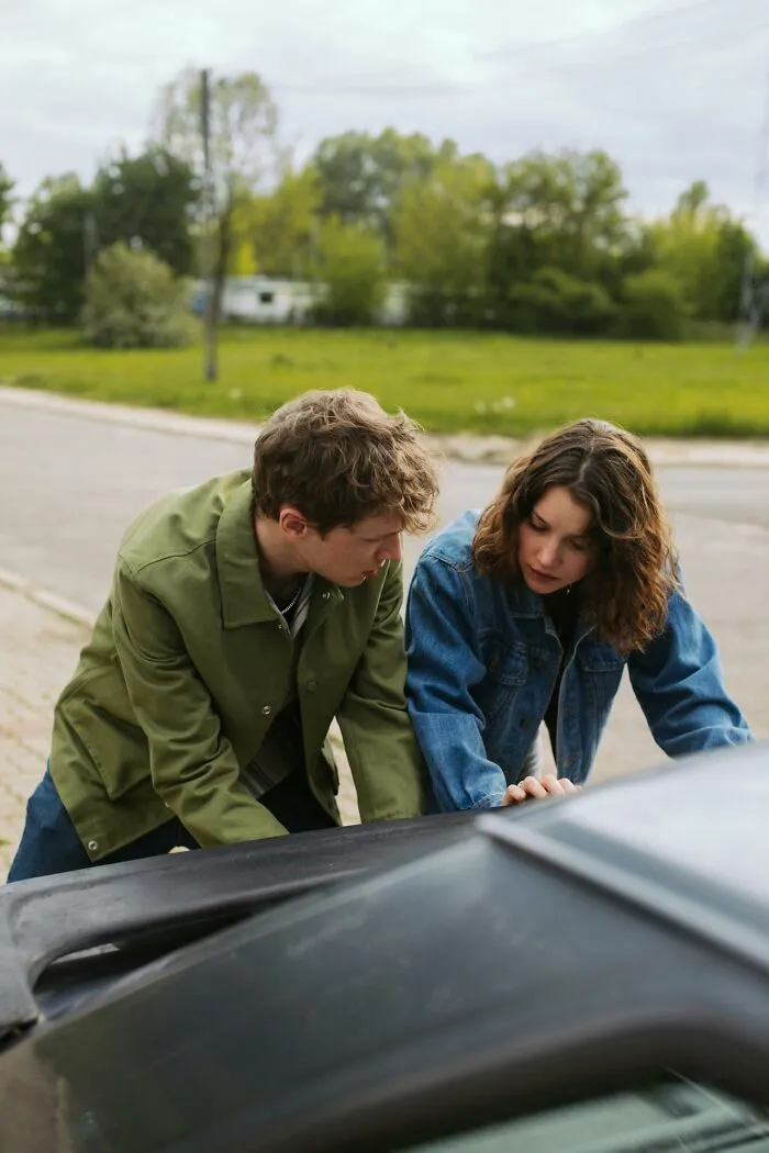 Two people examining an open car hood, illustrating true stories that sound bizarre and hard to believe moments.