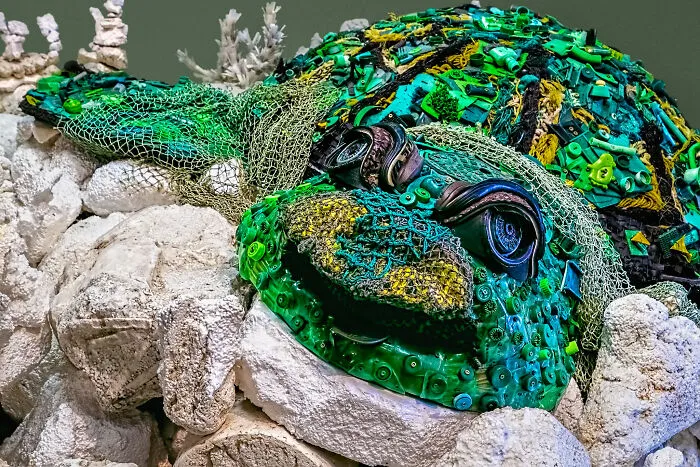 A sea turtle sculpture created from trash and fishing nets, showing how creative people transform waste into something artistic.