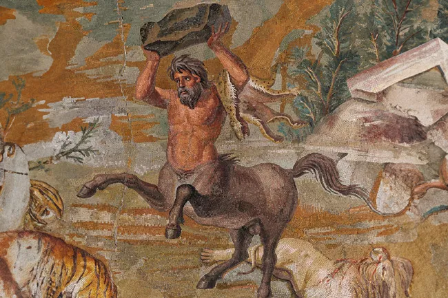 Ancient mural of a centaur holding a rock above its head, set in a natural landscape with animals nearby.