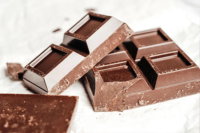 Close-up of broken dark chocolate bars with a rich texture, a popular nervous snack choice for many.