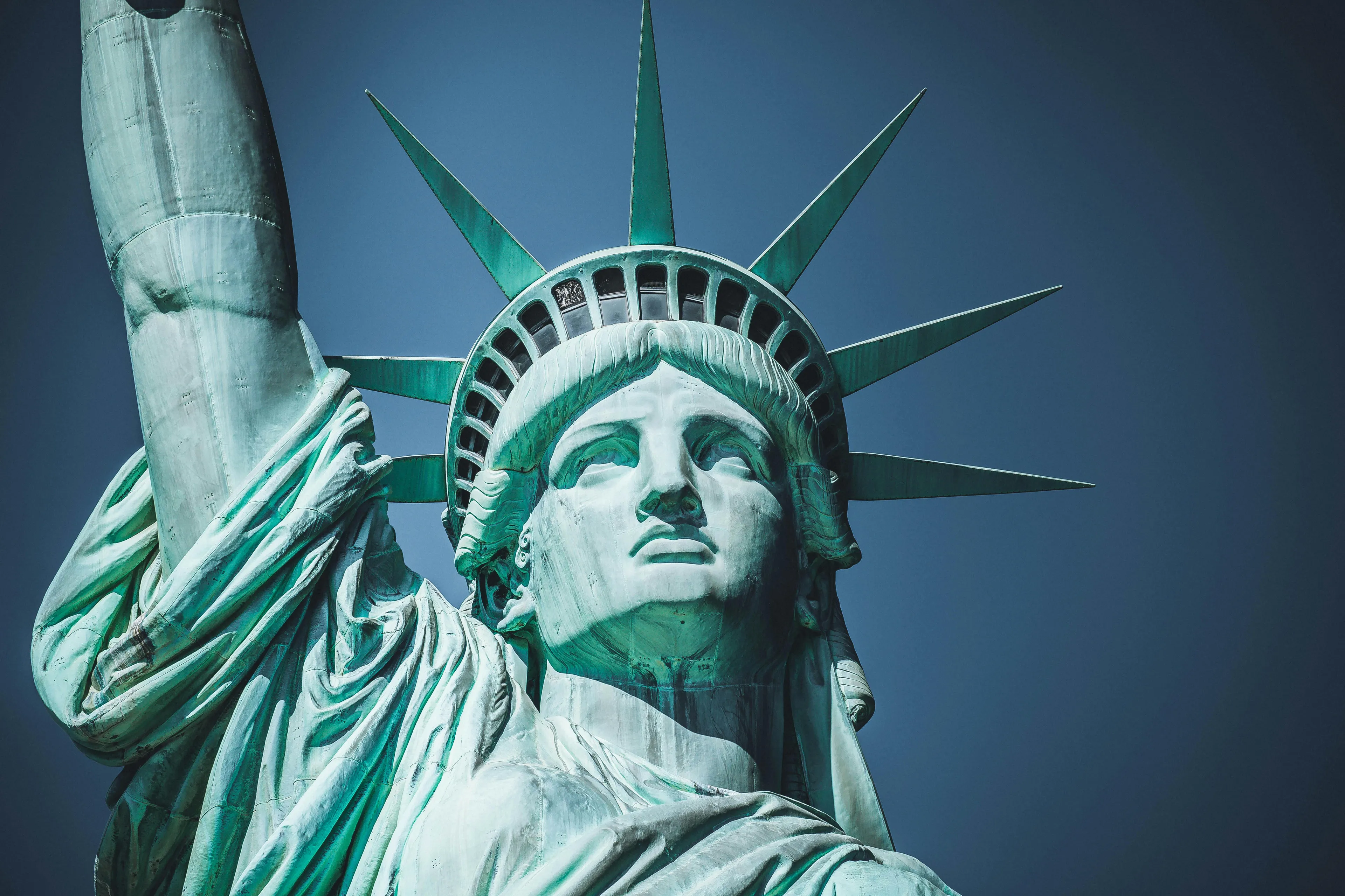Close-up of the Statue of Liberty against blue sky, highlighting which country gave the Statue of Liberty as a gift.